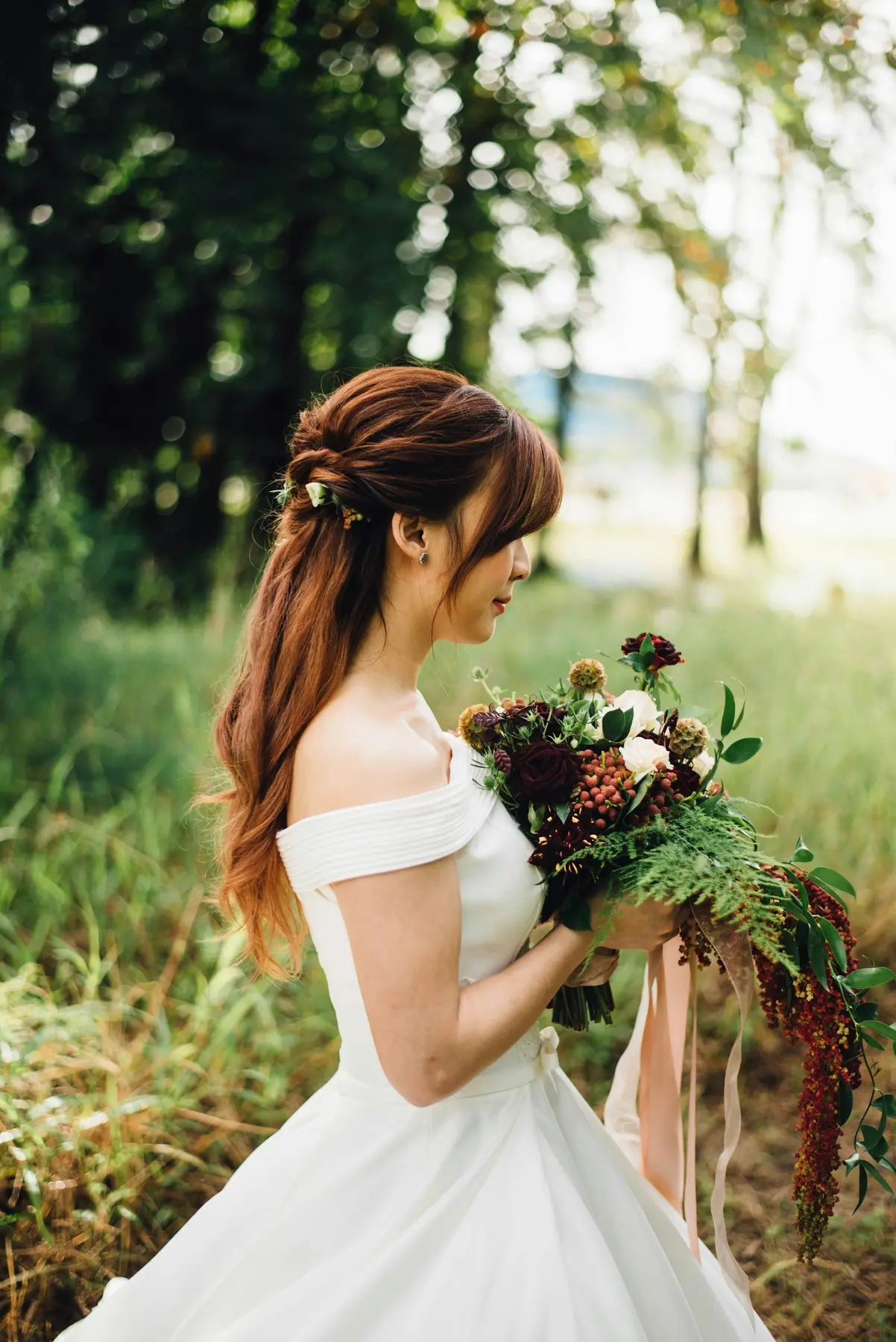 Bride holding her bouquet in a meadow