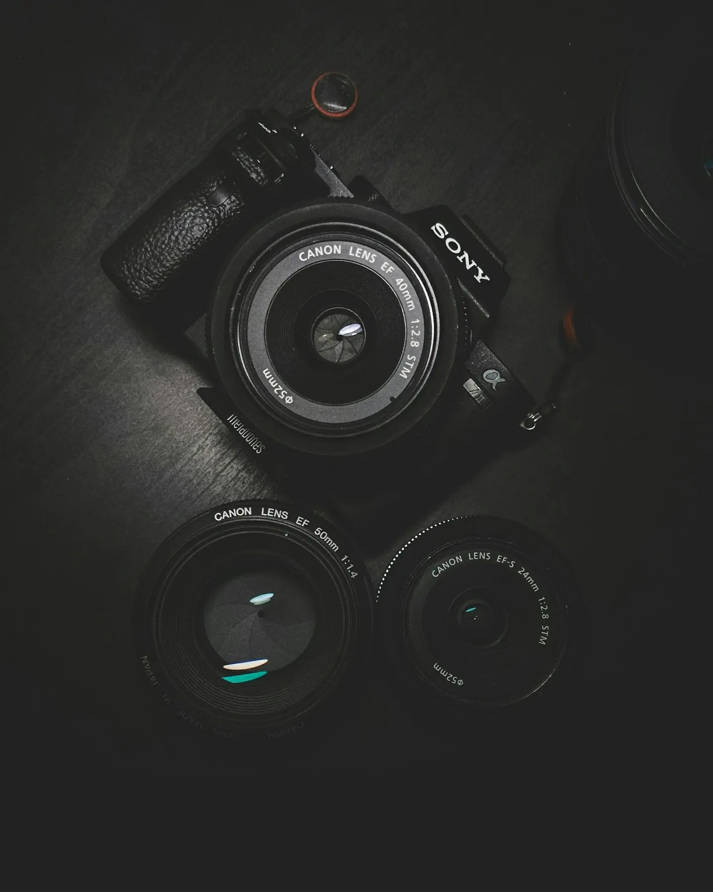 Camera body and lenses on a dark table