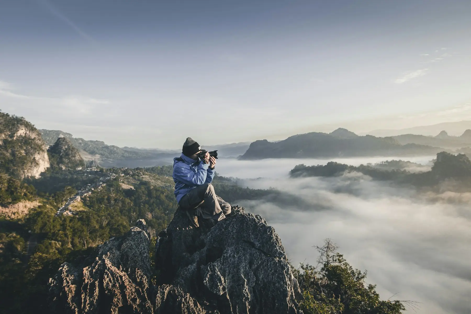 Photographer capturing a mountain view above the clouds